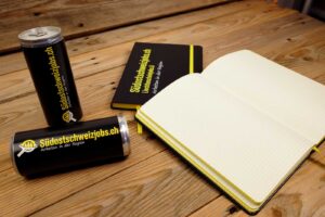 Notizbücher sowie Energydrink Dosen für Südostschweizjobs.ch