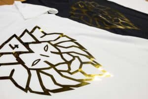 Hochwertiger Textildruck mit Goldfolie-Veredelung auf weißem und schwarzem T-Shirt mit geometrischem Löwen-Design